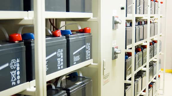 A shelf displaying a collection of batteries, organized in a straight line within a room.