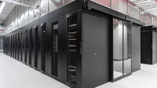 A spacious room featuring black servers lined against the walls.